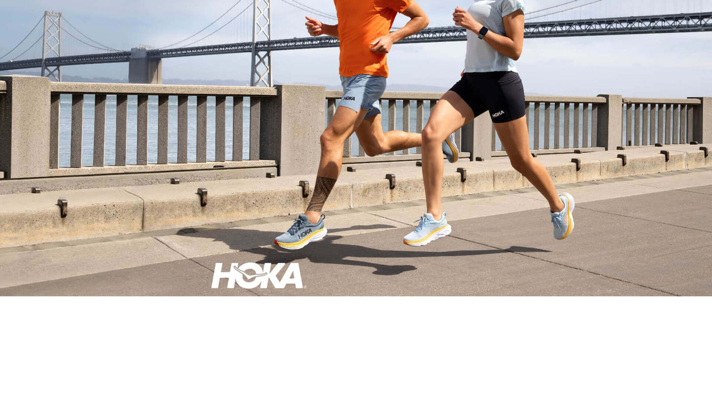Man and woman running with bridge in background